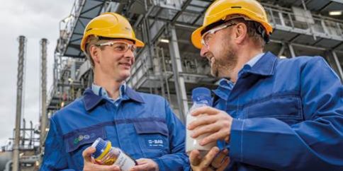 Stefan Gräter y Andreas Kicherer con una muestra de aceite de pirólisis y, por lo tanto, plástico producido frente al craqueador de vapor