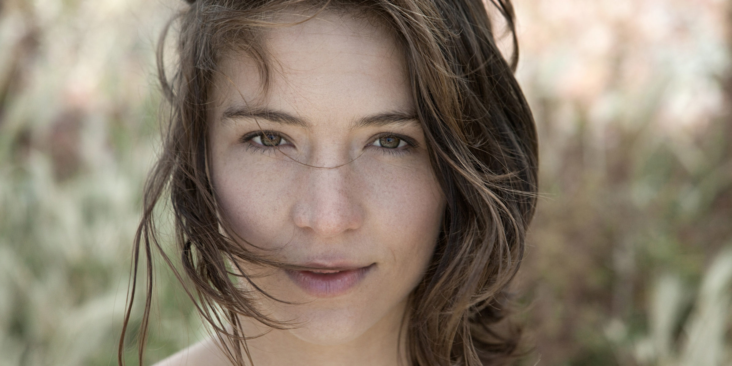 Young brunette woman alone outdoors, portrait