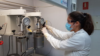 Hace poco más de un año que se lleva desarrollando una tesis doctoral, con mención Industrial, entre la Universidad de Huelva y Cepsa, encaminada al desarrollo de nuevas estrategias para la conversión directa de benceno en fenol. El fenol es producto fabricado en la Planta Química de Palos que se usa, principalmente, en la producción de resinas y agroquímicos; manufactura de nylon y otras fibras sintéticas; industria farmacéutica y clínica como un potente fungicida, bactericida, antiséptico y desinfectante; bisfenol A (materia prima para producir resinas epoxi y policarbonatos) y en el proceso de fabricación de ácido acetilsalicílico (aspirina), entre otras aplicaciones. El proceso actual de producción de fenol en la planta química de Cepsa en Palos parte de benceno y consta de muchas fases consecutivas hasta llegar a la molécula de fenol. Sustituir este proceso por otro de una sola fase supondría, no solo un hito tecnológico de carácter mundial, sino un considerable ahorro energético y una contribución notable a la sostenibilidad del proceso. La tesis industrial desarrollada en la Universidad de Huelva y codirigida por personal de Cepsa explora un método novedoso para pasar directamente de benceno a fenol mediante catalizadores que trabajan en medios no habituales. Los directores de la tesis son los profesores Ana Caballero y Pedro J. Pérez, del Laboratorio de Catálisis Homogénea (LCH) del Centro de Investigación en Química Sostenible (CIQSO), y Jesús Lázaro, coordinador del Departamento de Petroquímica y Nuevos Materiales del Centro de Investigación de Cepsa. La investigadora en dicho proyecto es la doctoranda Elena Borrego Blanco, Graduada en Química por la Universidad de Sevilla y Máster en Química por la Universidad de Barcelona. En este primer año, del total de tres de los que constará el periodo doctoral, ya se han producido los primeros resultados que permiten augurar el éxito del programa de trabajo inicialmente establecido. En esta modalidad de tesis doctoral industrial, uno de los requisitos es la contratación directa de la doctoranda por parte de Cepsa, empresa promotora de la investigación; por su parte, la Universidad de Huelva cofinancia con la compañía energética los costes salariales dentro de su Estrategia de Política de Investigación y Transferencia. Adicionalmente, los trabajos experimentales cuentan con el apoyo económico de la Catedra Fundación Cepsa que cubre los gastos de materiales y reactivos derivados de estas investigaciones a través del Convenio de Colaboración que cada año suscribe con la Onubense. La dilatada experiencia de los investigadores del CIQSO, unida a la experiencia del Centro de Investigación de Cepsa en el campo de la oxidación de compuestos aromáticos, se han unido para abordar este complejo tema en el que se espera lograr un avance, no solo en el conocimiento científico, sino en la posible aplicación industrial de los conocimientos generados. El LCH es uno de los grupos de investigación con mayor actividad, en lo que a resultados de investigación se refiere, de la Universidad de Huelva. Desarrolla proyectos de investigación de diversa naturaleza, financiados a partir de convocatorias públicas competitivas a nivel estatal o autonómico, así como por diversas empresas del ámbito químico. Su actividad ha sido reconocida a través de diversos premios y distinciones internacionales y nacionales. En sus 24 años de historia este grupo, que fue fundado en 1996 por el profesor Pérez, ha dado luz a 20 Tesis Doctorales ya defendidas, y otras seis que se encuentran actualmente en fase de desarrollo, entre las que se incluye esta de carácter industrial. Desde la Universidad de Huelva se ha subrayado que la alianza con Cepsa permite la constante transferencia del conocimiento, uno de los valores más importantes de la UHU, y es un instrumento esencial para el desarrollo de la investigación y la formación y empleabilidad de los estudiantes. Las cátedras de la Fundación Cepsa Las cátedras de la Fundación Cepsa en las Universidades de Huelva, Cádiz, Sevilla, La Laguna y Politécnica de Madrid, se refuerzan continuamente gracias a las aportaciones y a la implicación de los profesionales de la Compañía y de las instituciones académicas comprometidas, en la mejora de investigación, la formación, flujo de conocimiento y la innovación. Las Cátedras Fundación Cepsa han permitido a miles de alumnos acercarse al mundo laboral y aproximar a los profesores universitarios a la realidad de los sectores energético y químico. El intercambio de conocimientos y experiencia entre los profesionales de Cepsa y docentes y alumnos universitarios supone, desde hace dos décadas, el enriquecimiento profesional de todos ellos. Por todo ello, Cepsa es una gran aliada de estas universidades.